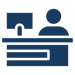 A simplified graphic of a person sitting at a concierge desk with a computer monitor.
