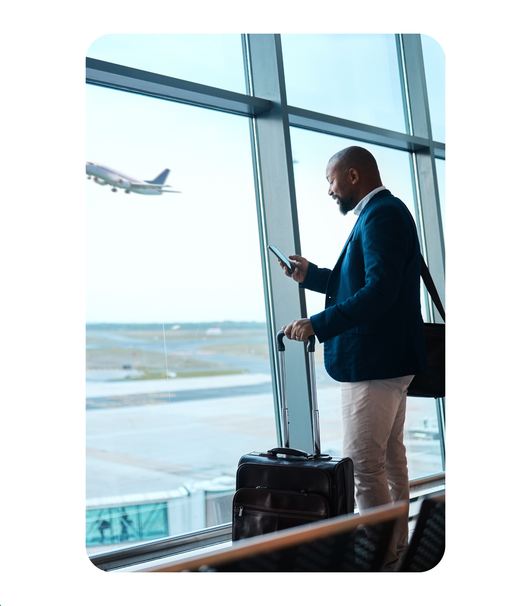 Business traveler on phone beside an airport window