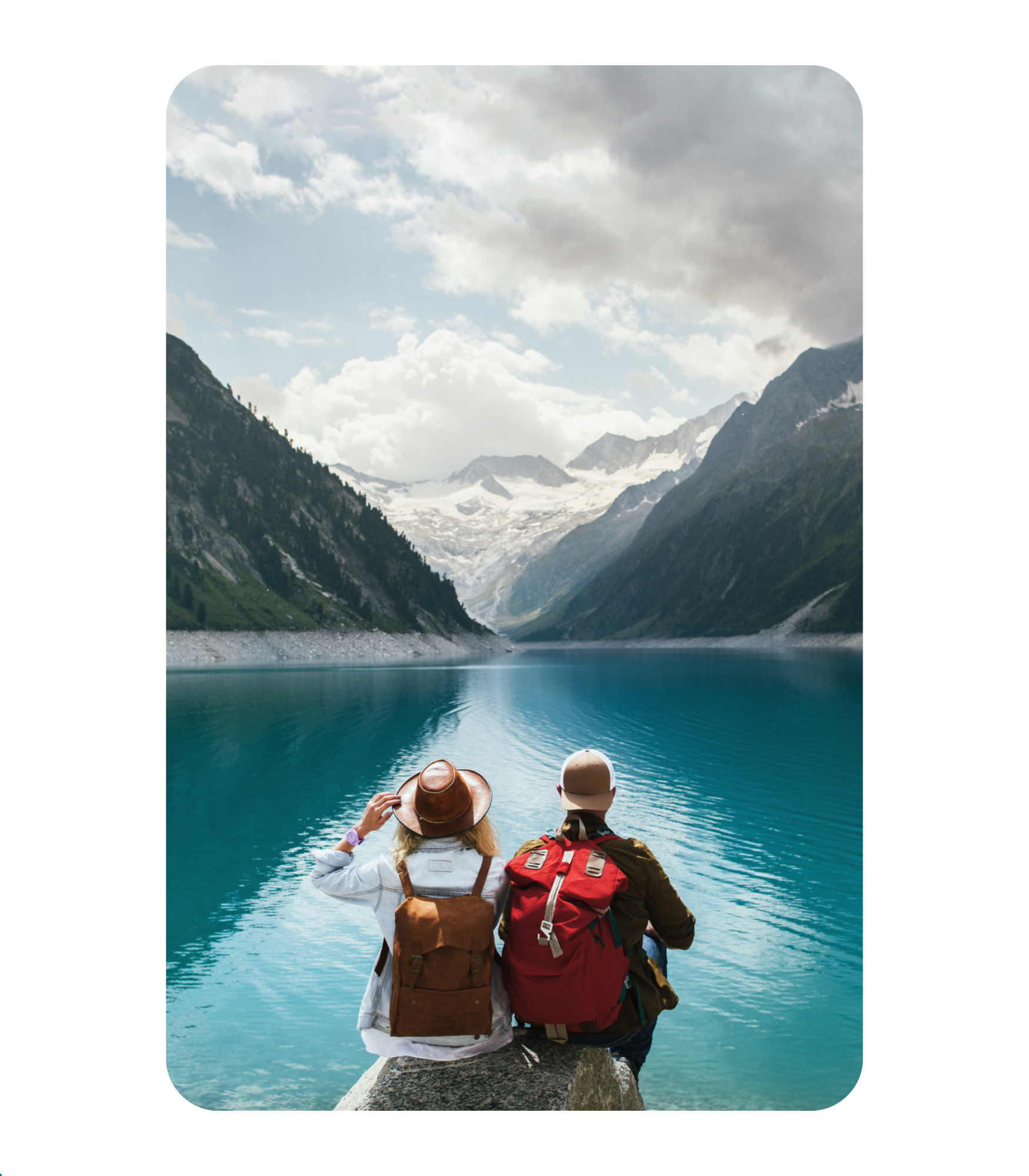 couple looking out over blue lake with Mountains in the background