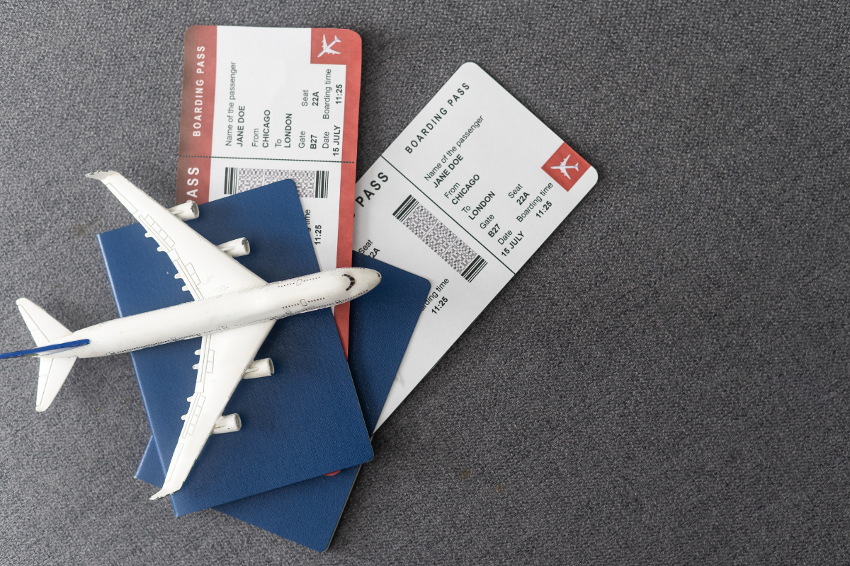 model airplane sitting on top of two passports and two airline tickets