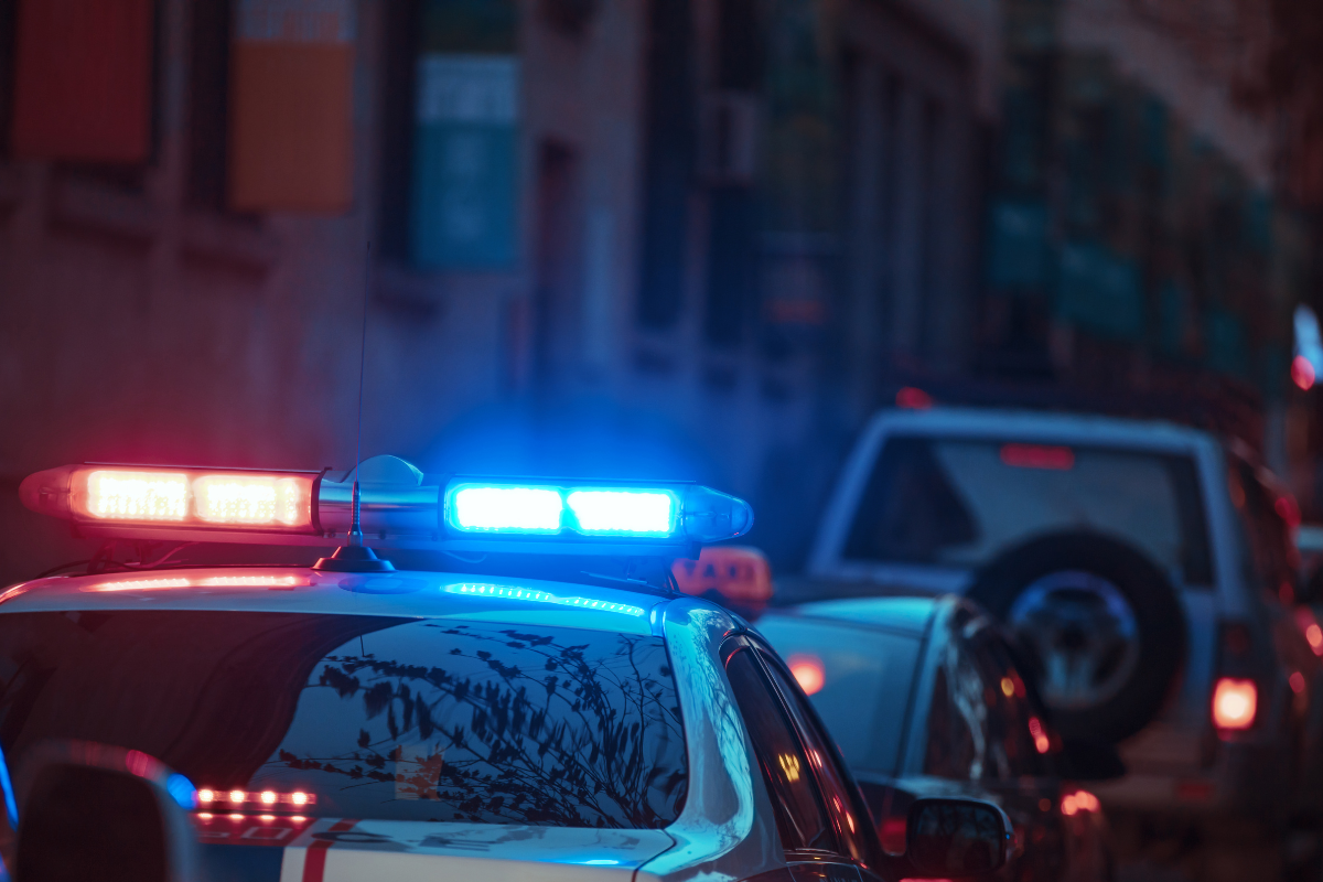 a police car sitting in traffic with red and blue police light on